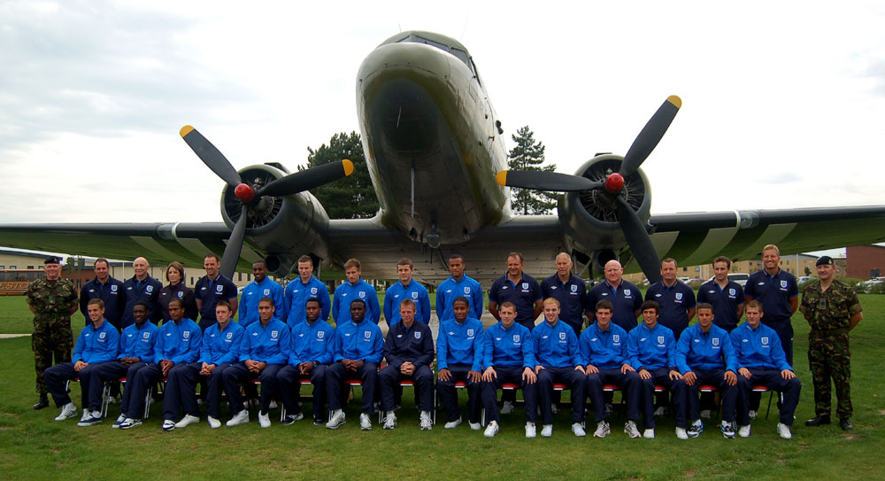 The Under-21s line up for a photo with the Dakota World War II transport aircraft
